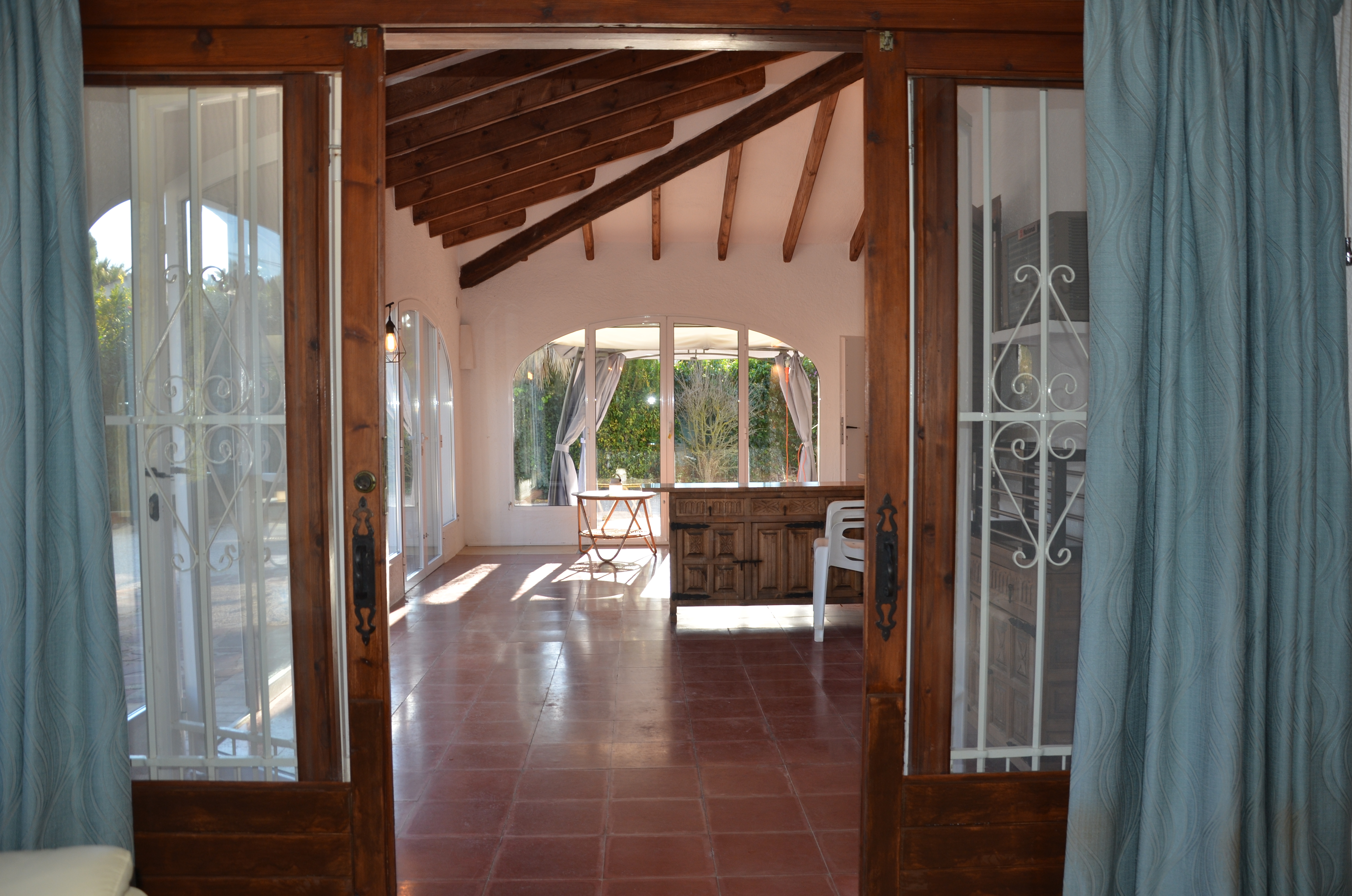 Sunroom with wooden beams and garden access